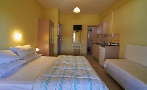 サルティにあるSarti Paradiseのベッド2台とキッチンが備わるホテルルームです。