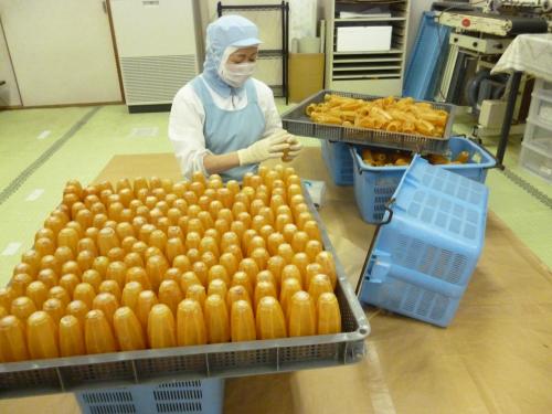 a person in a kitchen with a bunch of donuts at Hakodate Motomachi Hotel in Hakodate
