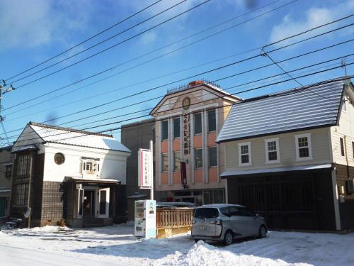 a car parked in front of a building in the snow at Hakodate Motomachi Hotel in Hakodate