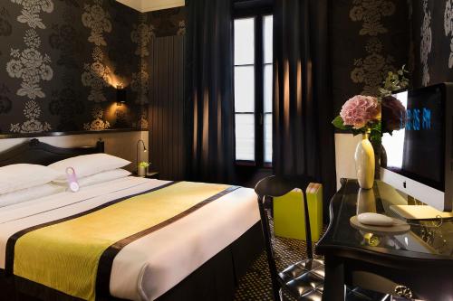 パリにあるホテル デザイン ソルボンヌのベッドルーム1室(ベッド1台、デスク、コンピュータ付)