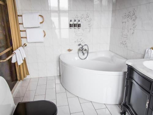 Baño blanco con bañera y lavamanos en Hotel Eggers, en Gotemburgo