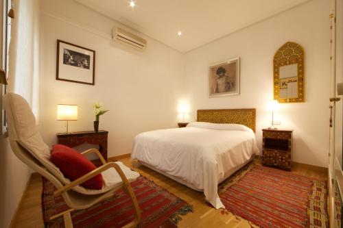 マドリードにあるChueca Dreamsのベッドルーム1室(ベッド1台、椅子、鏡付)