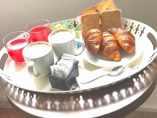 a plate of croissants and bread on a table with drinks at Duomo View in Florence