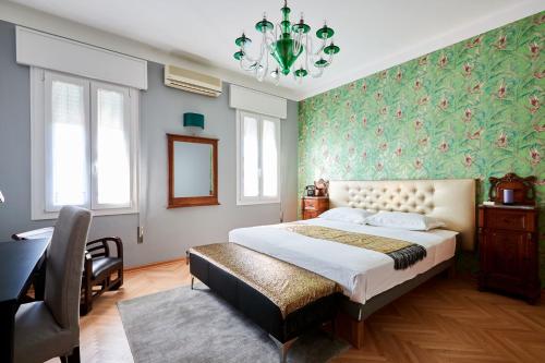 a bedroom with a bed and a chair and a chandelier at La Serliana - Bed&Breakfast in Vicenza