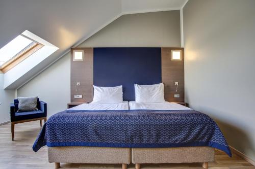 a bedroom with a large bed and a blue wall at Hotel Orangerie in Vienna