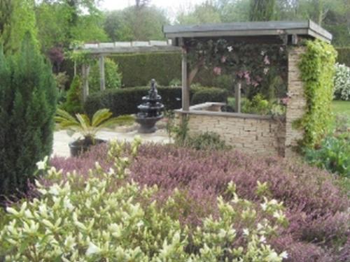 a garden with a fountain in the middle of a garden at Chambre D'Hotes Miraflores in Malestroit