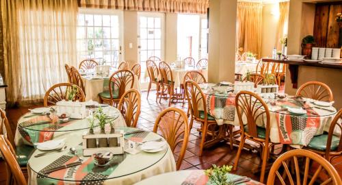 a dining room with many tables and chairs at Oxford Lodge Vryheid in Vryheid