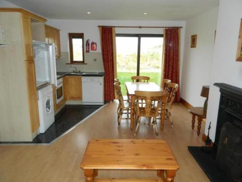 uma cozinha e sala de jantar com uma mesa e uma mesa e cadeiras em Kinsale Coastal Cottages em Garrylucas