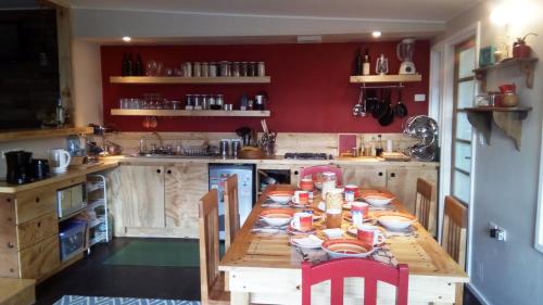 a kitchen with a table and chairs and a refrigerator at Hostal Treehouse Patagonia in Puerto Natales