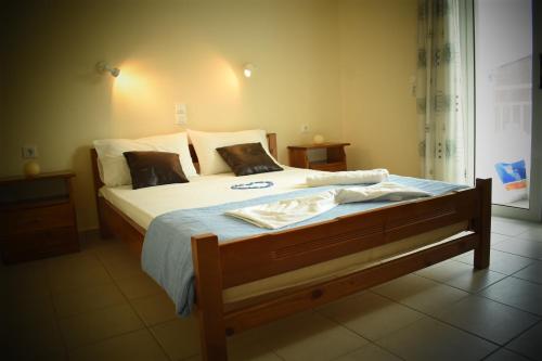 ein Schlafzimmer mit einem großen Bett mit weißer Bettwäsche und Kissen in der Unterkunft Parashis Studios in Alykes