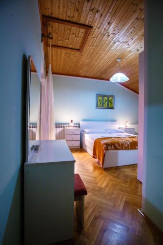 a bedroom with a bed and a desk in it at Apartments Slavko in Supetarska Draga