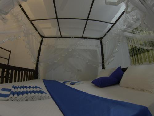 a bed in a tent with blue pillows on it at Resort of Happiness in Mirissa