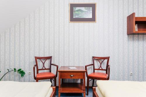 a room with three chairs and a table and a bed at Resort Malevil in Jablonné v Podještědí