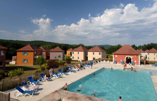 a pool at a resort with people sitting in chairs at Terres de France - Domaine de Claire Rive in Prayssac