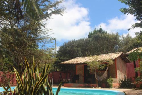 a house with a swimming pool in a garden at Chales Jack & Jill in Pipa