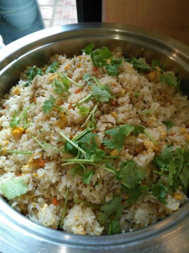 een metalen kom gevuld met rijst en koriander bij Stamp Hills Resort in Suan Phung
