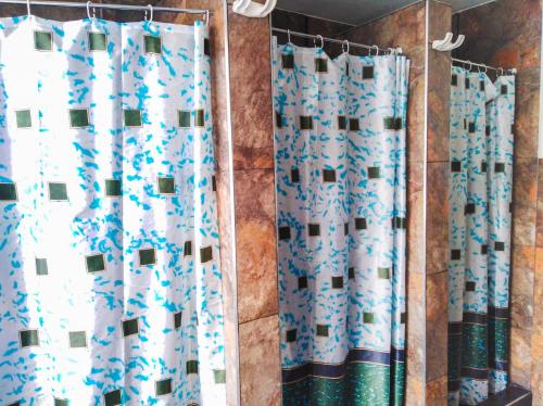 a bathroom with blue and white shower curtains at Hostal CQ Chapinero in Bogotá