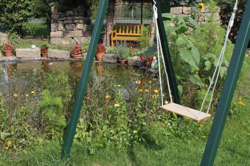 a swing in a garden with a pond at "Altjessen 57" in Pirna