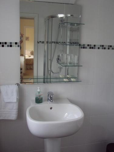 a white sink in a bathroom with a mirror at Ryebrook House in Killarney