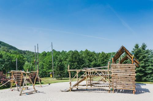 a playground in a park with a wooden structure at Resort Malevil in Jablonné v Podještědí