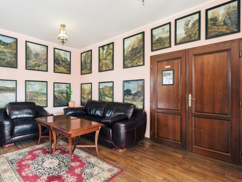 a living room with a leather couch and a table at Resort Malevil in Jablonné v Podještědí