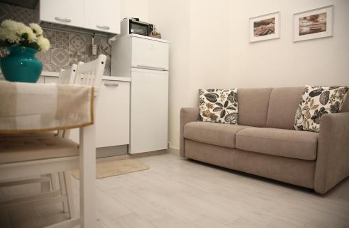a living room with a couch and a kitchen at La dimora di Clara in Trapani