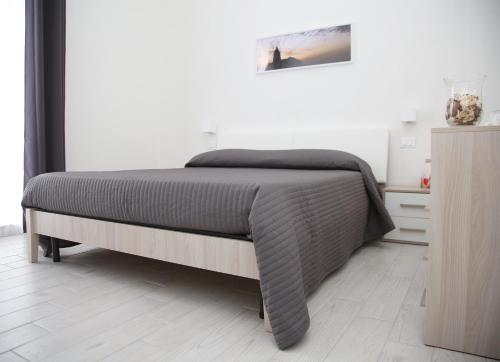 a bedroom with a bed and a dresser at La dimora di Clara in Trapani