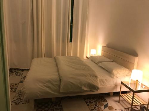 a bedroom with a bed with two lamps on it at Al Bishara Guest House in Nazareth