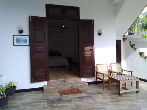 a room with a door and two chairs and a table at Hotel La Felicita in Mirissa