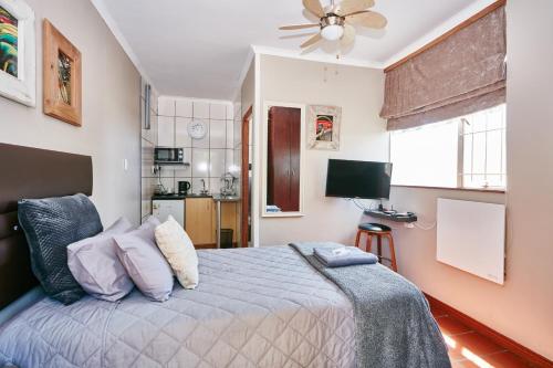 1 dormitorio con 1 cama y ventilador de techo en 1202 on Cowgill en Pretoria