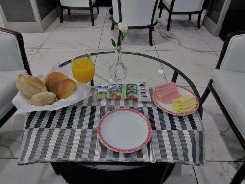a glass table with a plate of food and orange juice at Hotel Excelsior in Lisbon