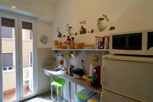 una cucina con bancone e forno a microonde in cima a un frigorifero di B&B Acasadibarbara a Roma