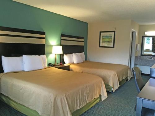 a hotel room with two beds in a room at GuestHouse Inn Dothan in Dothan