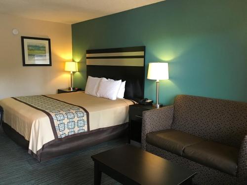 una camera d'albergo con letto e sedia di GuestHouse Inn Dothan a Dothan