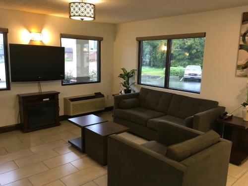 a living room with a couch and a flat screen tv at GuestHouse Inn Dothan in Dothan