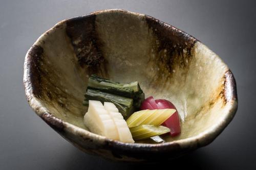 a wooden bowl filled with different types of fruits and vegetables at Kurotake in Achi
