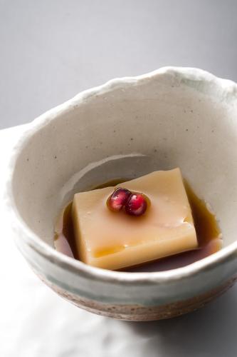 a bowl with a piece of cheese and fruit on it at Kurotake in Achi