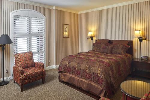 a bedroom with a bed and a chair and a window at Hotel Mac in Richmond