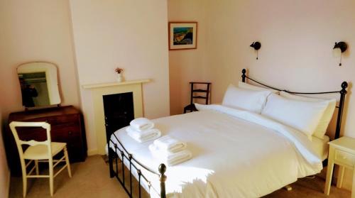 a bedroom with a bed with towels on it at Milliner's Cottage in York