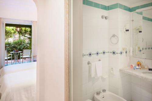 a bathroom with a tub and a sink and a toilet at Hotel Continental Ischia in Ischia