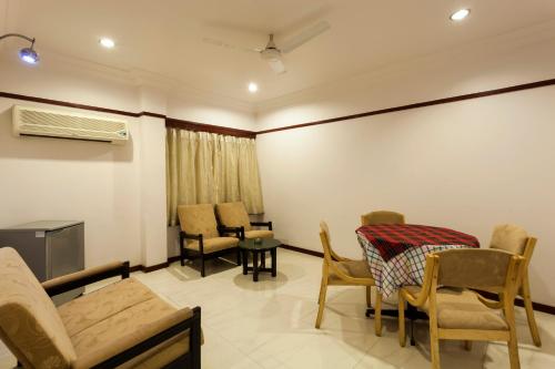 a living room with a table and chairs at Hotel Vrishali Executive in Kolhapur
