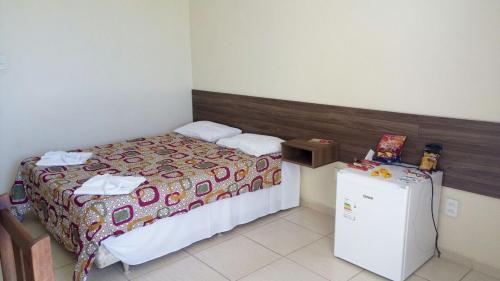 a bedroom with a bed and a small refrigerator at Hotel Potencial in Conselheiro Lafaiete