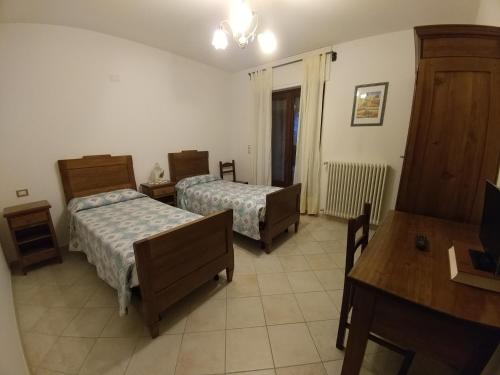 a room with two beds and a table and a desk at Agriturismo La Cinciallegra in Riva presso Chieri