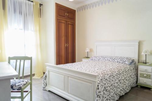 コルドバにあるCasa Ruanoの白いベッドルーム(ベッド1台、椅子付)