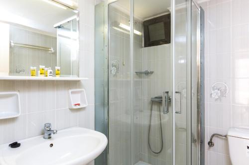 a bathroom with a glass shower and a sink at Rosebay Apartments in Sfakaki