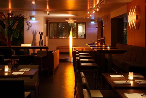 a restaurant with tables and chairs and a bar at Hotel Bosco in Kingston upon Thames