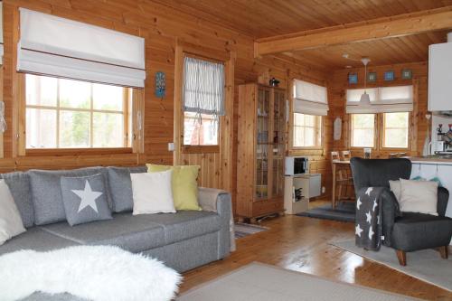Una sala de estar con un sofá y una cocina. en Lovely Cottage by Ounasjoki, en Marraskoski