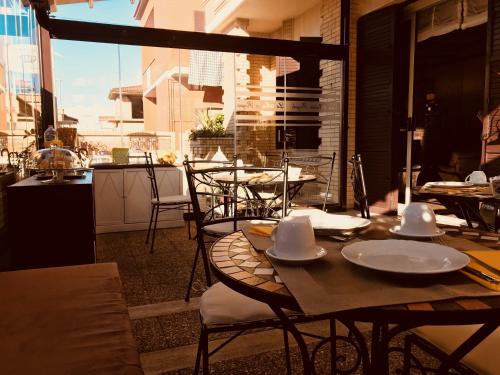 un tavolo con ciotole e piatti su un patio di La Maison Royale Bed & Breakfast a Fiumicino