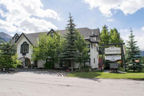 a large white building with a sign in front of it at The Georgetown Inn in Canmore