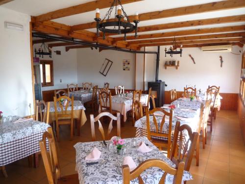 a dining room with tables and chairs in a room at El Esguízaro in Berzosa del Lozoya